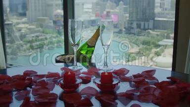 香槟和酒杯放在一张桌子上，上面有红色的花瓣，在<strong>大视野</strong>中